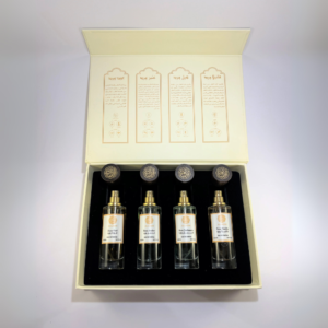 AlGadhi Perfume Set featuring four fragrances: Vanilla Rose, Amber Rose, Cardamom Rose, and Oud Rose elegantly arranged in a luxurious gift box