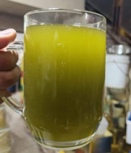 كوب زجاجي يحتوي على زيت زيتون فلسطيني طازج بلونه الأخضر الطبيعي.