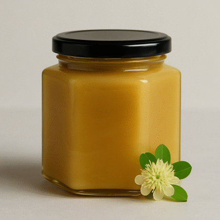 Hexagonal glass jar of Baladi Sidr Honey from Asir with golden color and Sidr flower on white background